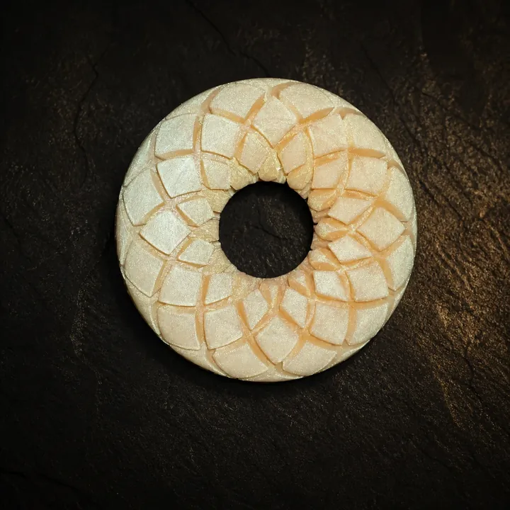 Four-inch Rodin coil in a pearl ivory finish on dark slate.